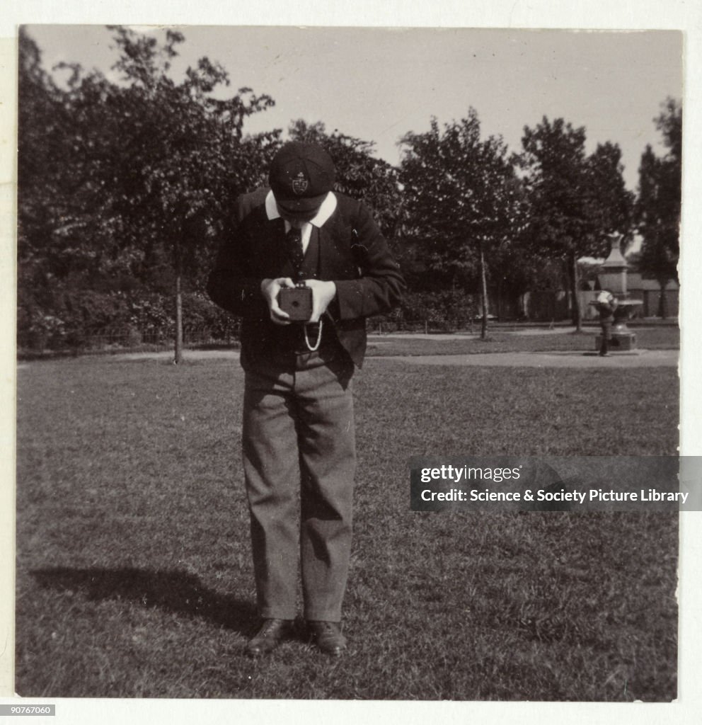 Schoolboy taking a photograph, c 1905.