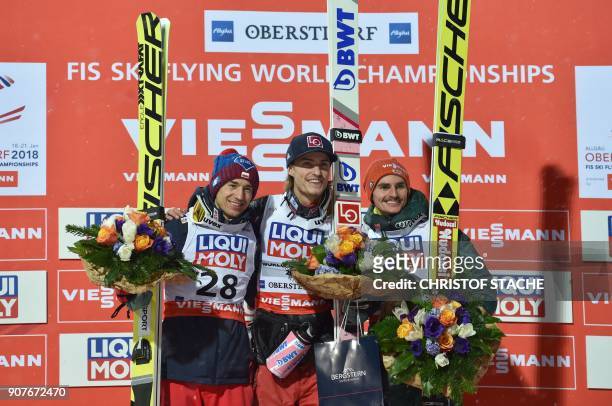 Poland's Kamil Stoch , winner Norway's Daniel Andre Tande and Germany's Richard Freitag celebrate on the podium after the individual competition of...