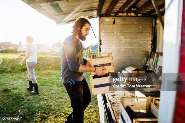 urban farmers loading truck with freshly harvested goods - agricultural activity stock-fotos und bilder