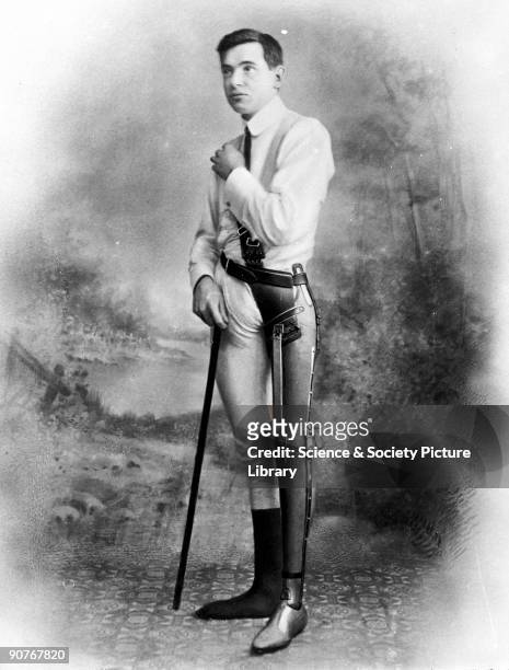 Studio photograph of a man wearing an artificial leg. The leg was manufactured by James Gillingham , a boot- and shoemaker based in Chard, Somerset....
