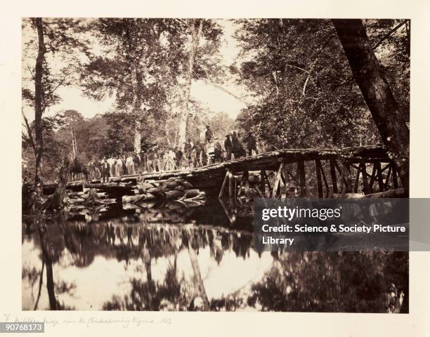 Albumen print of a column of soldiers crossing a wooden bridge over the Chickahominy River in Virginia, by Alexander Gardener from a negative...
