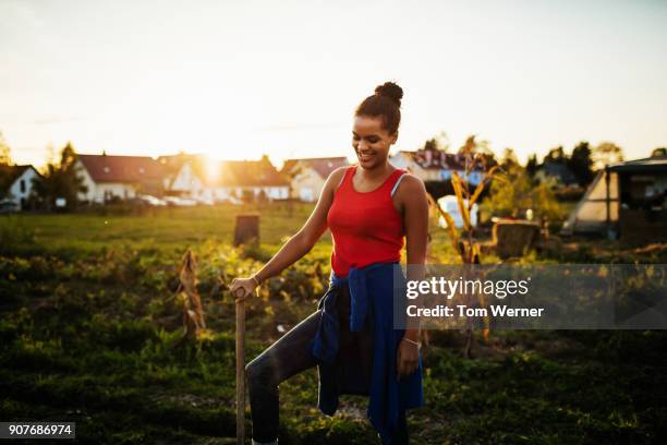 young urban farmer smiling while she works her plots - black farmer stock pictures, royalty-free photos & images