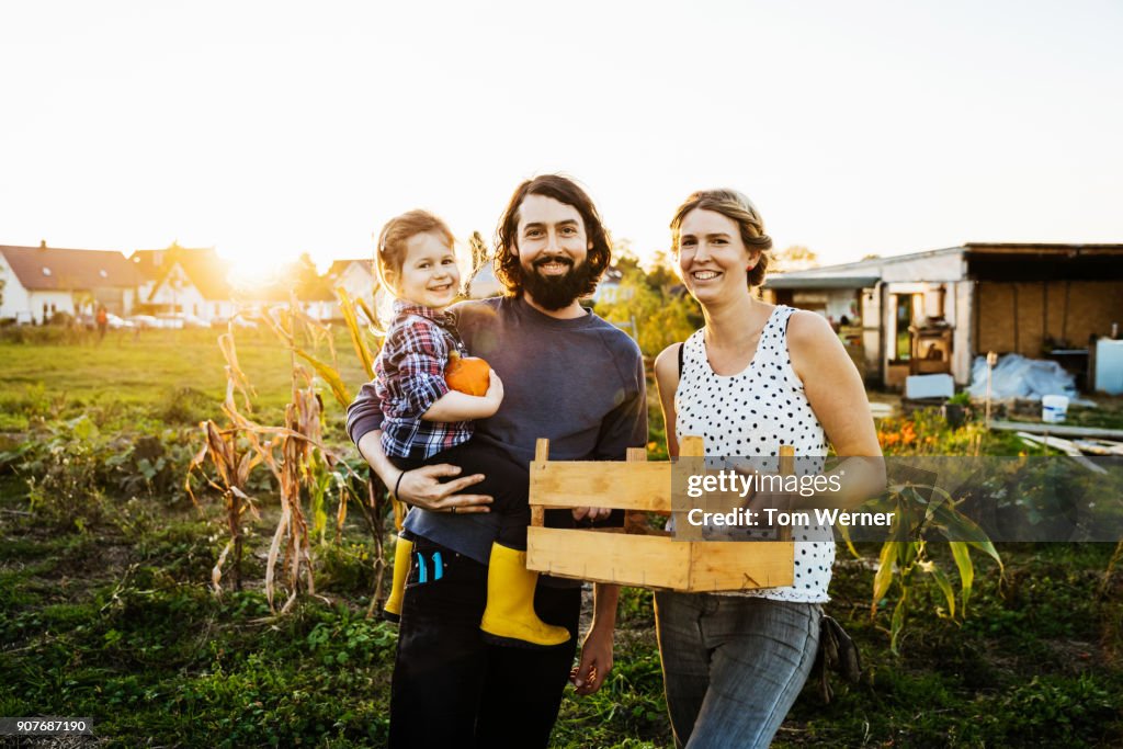 Portrait Of Urban Farming Family Together At Their Plot