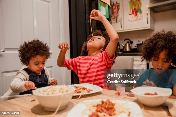 bambini che mangiano spaghetti e yogurt - feeding foto e immagini stock