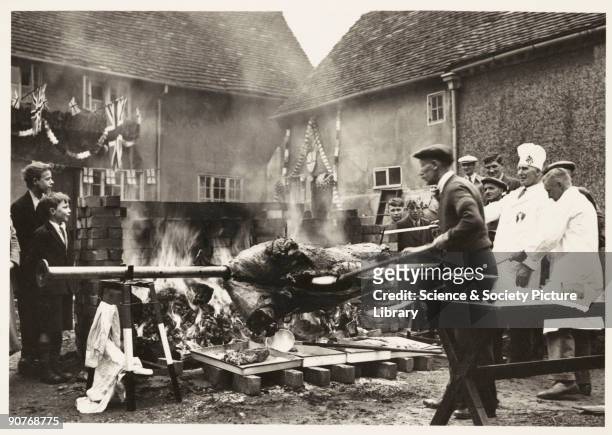Photograph of an ox being roasted in King's Norton, Birmingham, taken by an unknown photographer in May 1937. The ox roast was part of celebrations...