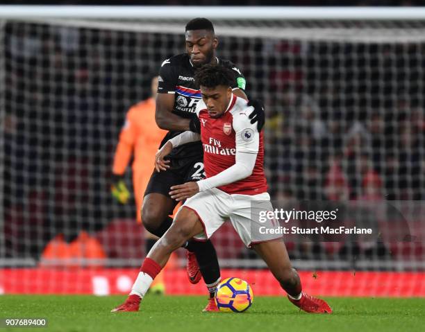 Alex Iwobi of Arsenal challenged by Timothy Fosu-Mensah of Crystal Palace during the Premier League match between Arsenal and Crystal Palace at...