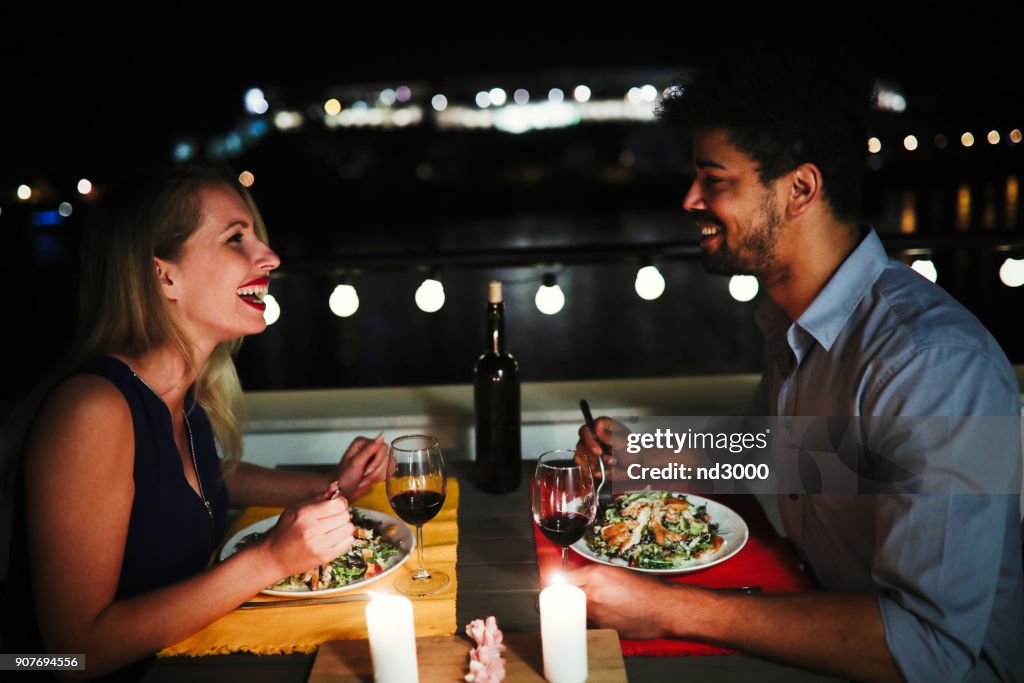 年輕美麗的夫婦在屋頂上共進浪漫晚餐