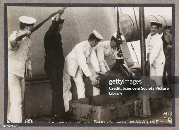 A photograph of sailors loading shells into HMS Elizabeth's magazine ...