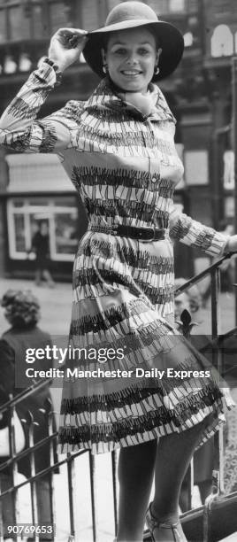 Model wearing a fringe-pattern dress with hat, cravat and belt.
