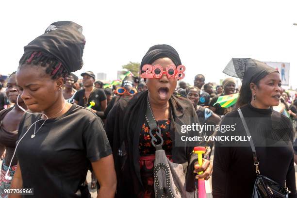 Togolese woman dressed in black and wearing a pair of masquerade sunglasses, takes to the streets of the capital Lome during a protest rally against...