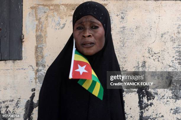 Togolese woman with the national flag watches a protest rally by women in the capital Lome against Togo's president on January 20, 2018. - A...