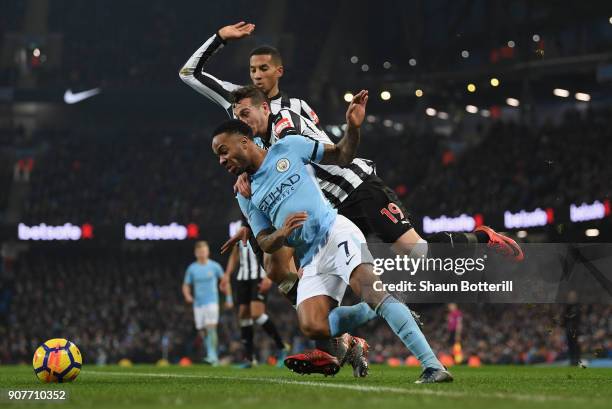 Raheem Sterling of Manchester City is tackled by Javi Manquillo and Isaac Hayden of Newcastle Unitedduring the Premier League match between...