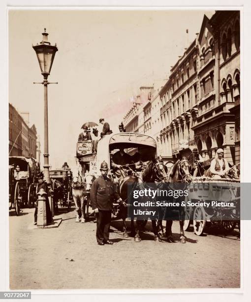 Photograph by Paul Martin of a busy London street, taken about 1900. A policeman controls the horse-drawn traffic on this busy street. A horse-drawn...