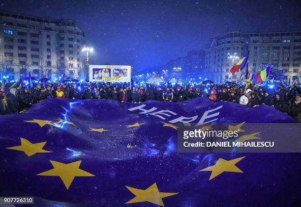 Demonstrators hold a giant flag of the European Union as they stage an anti-government and anti-corruption protest in front of the Romanian...