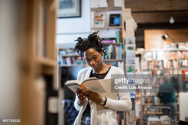 young female customer reading book - abundance stock pictures, royalty-free photos & images