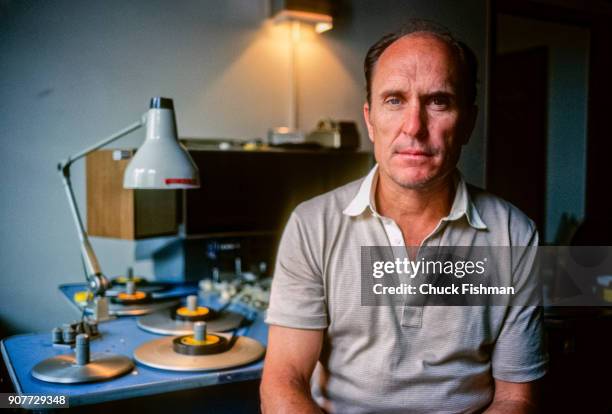 Portrait of American actor and film director Robert Duvall as he sits in a film editing suite, New York, New York, July 1981. Behind him is Steenbeck...