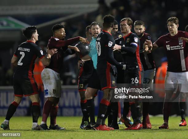 Referee Brett Huxtable attempts to keep order as players clash prior to Chuks Aneke of Milton Keynes Dons is shown a red card during the Sky Bet...