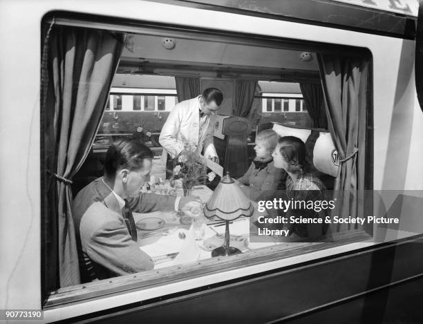 Passengers in a first class Great Western Railway dining car. Passengers could have a three course meal, including a roast dinner, for around 3/6 ....
