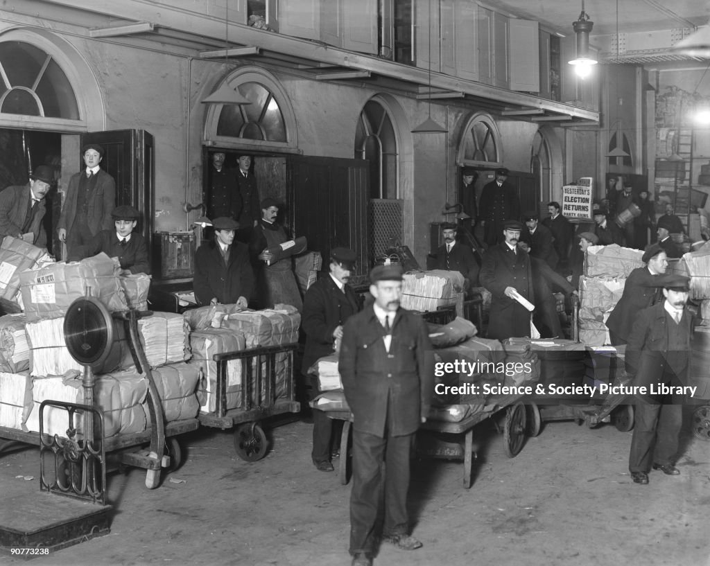 Newspapers being loaded onto a train, Paddington Station, London, c 1910.
