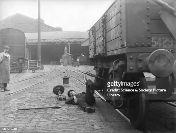 Worker simulating an accident at the Great Western Railway's Paddington Station. This posed photograph was taken as part of a safety campaign to...