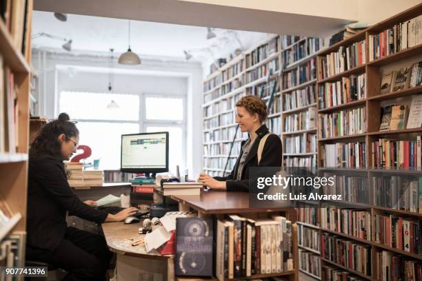 females at checkout of bookstore - bookshop stock-fotos und bilder