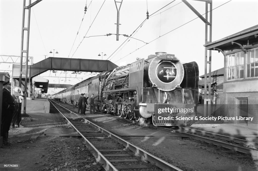 Steam locomotive and passenger train, Kroonstad Station, South Africa, 1968.