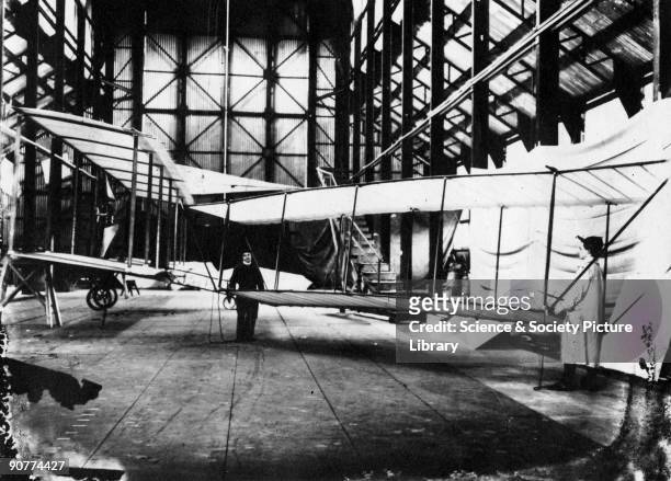 Leon and Vivian Cody are seen manhandling a model glider in the foreground. Taken in the Farnborough airship shed. Samuel Franklin Cody was a Texan...