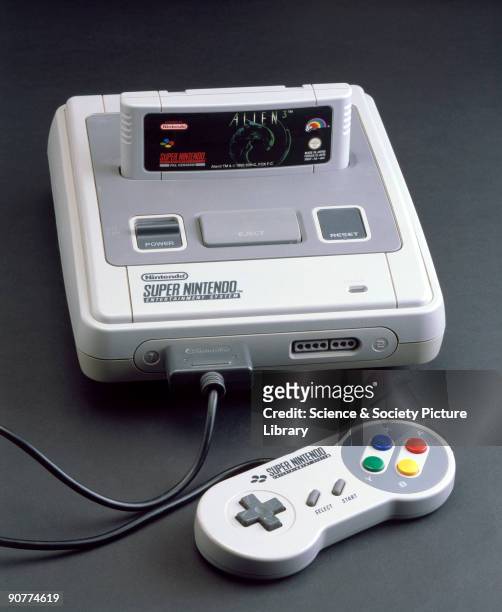 Super Nintendo Entertainment System, 1992. Computer games console with 'Alien 3' game cartridge and one hand-held controller made by Nintendo, Japan.