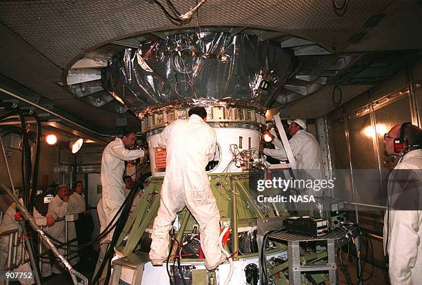 Workers at Launch Pad 17-A, Cape Canaveral Air Station, connect the third stage of a Boeing Delta II rocket , which is already attached to the...