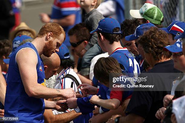 Adam Cooney of the Bulldogs signs autographs for the fans during a Western Bulldogs AFL training session at Whitten Oval on September 15, 2009 in...