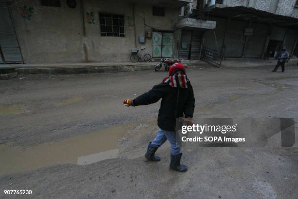 Boy seen playing in the street during the rain in a village outside Damascus. Despite the ongoing conflict in Syria, life in government-held parts of...