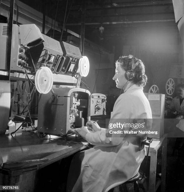 The sound system of a Bell and Howell Filmosound 640 projector being given a final acoustic control test by a technician at the factory on British...
