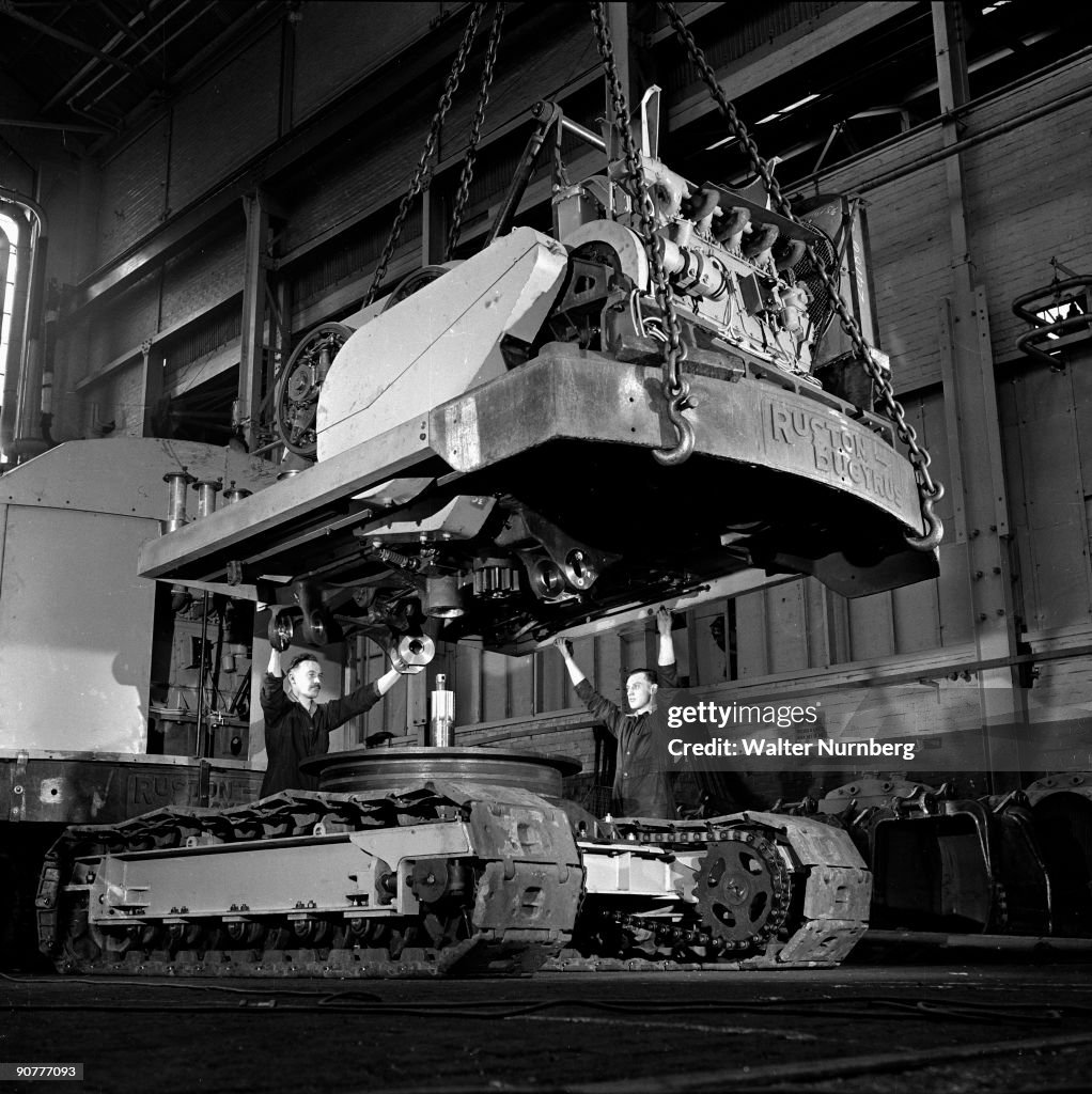 A fitter gives directions to a crane to lower a track on to a set of ...