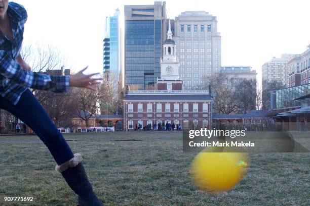 Friends play a lawn game in front of tourists waiting in line to see the Liberty Bell in front of the shuttered Independence Hall after the...