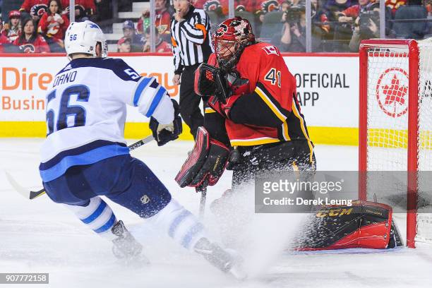 Mike Smith of the Calgary Flames makes a glove save on the shot of Marko Dano of the Winnipeg Jets during an NHL game at Scotiabank Saddledome on...
