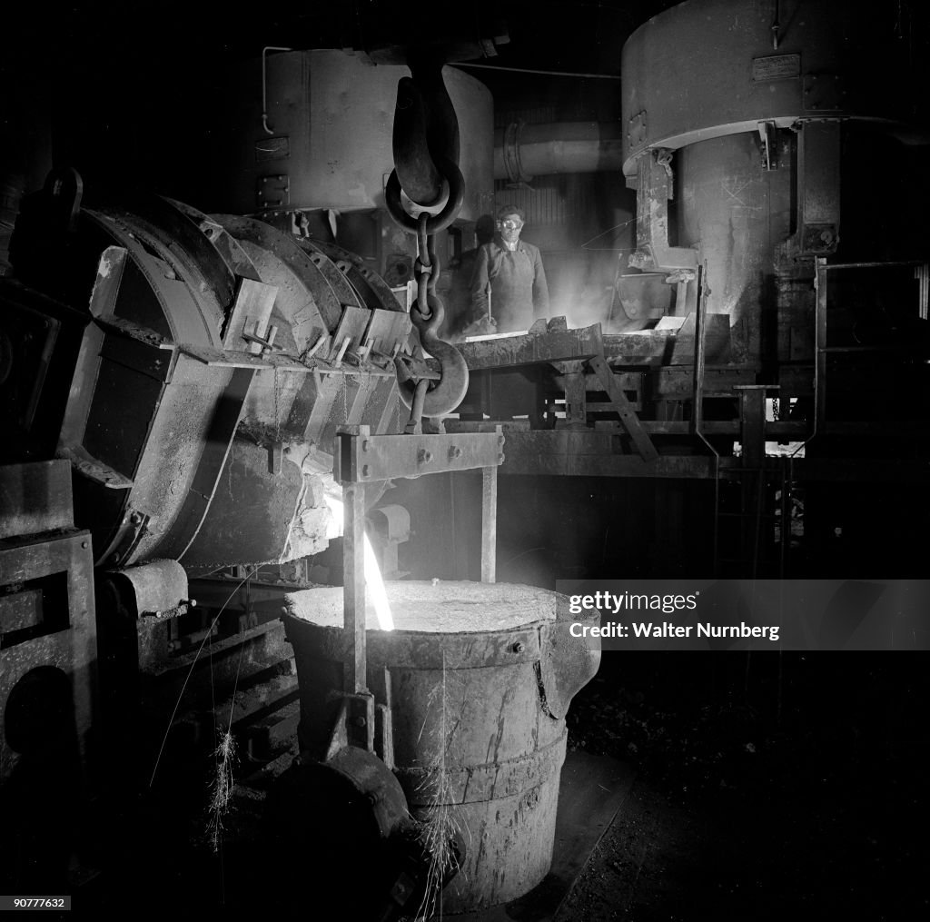 Molten metal pours from cupola into large ladle in foundry, Darlington, 1966.
