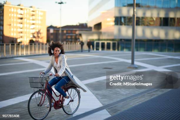 donna afroamericana in bici - black woman riding bike foto e immagini stock