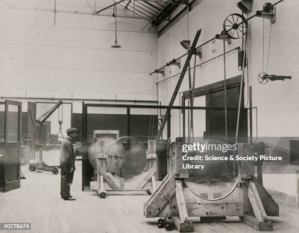 Photograph showing the interior of the optical workshop of Sir Howard Grubb, Parsons and Company in Newcastle upon Tyne. In this view, a pair of...