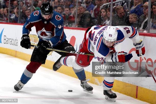 Mark Barberio of the Colorado Avalanche fights for the puck on the boards against Mika Zibanejad of the New York Rangers at the Pepsi Center on...