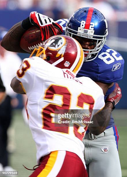Mario Manningham of the New York Giants eludes a tackle attempt from DeAngelo Hall of the Washington Redskins enroute to a touchdown on September 13,...