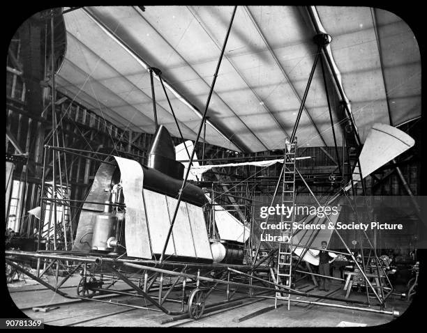 Photograph of the aircraft under construction in the hangar, with the steam boiler prominent. Sir Hiram Stevens Maxim designed and built this flying...