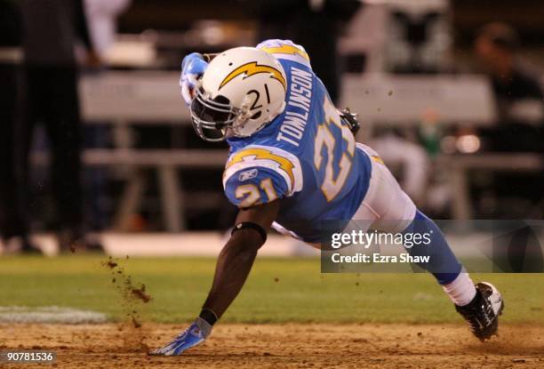 LaDainian Tomlinson of the San Diego Chargers falls to the turf after he ws tripped up on a running play against the Oakland Raiders on September 14,...