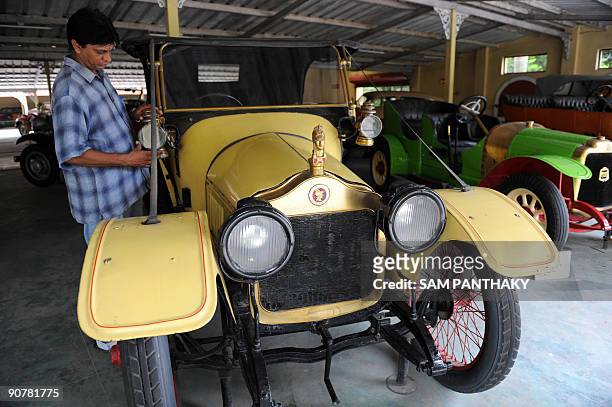 Car Maintenance Supervisor Sunil Shukla adjusts the lamp of a Belgian 'Minerva', 1906 model once owned by Sheikh Al Sabah of Kuwait on display at...