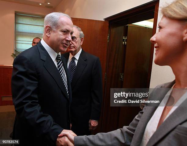 Israeli Prime Minister Benjamin Netanyahu greets an unidentified State Department official as he and U.S. Special Envoy George Mitchell head into his...