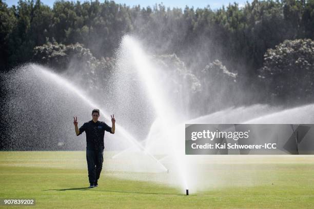 Man reacts as the sprinklers are turned on following the ICC U19 Cricket World Cup match between the West Indies and Kenya at Lincoln Oval on January...