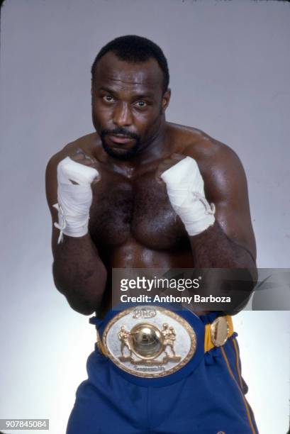 Portrait of American Light Heavyweight and Cruiserweight boxer Dwight Muhammad Qawi as he poses, fists raised, in shorts and a championship belt, New...