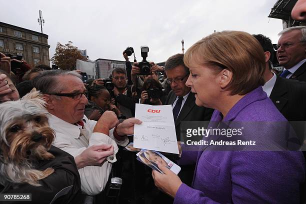 German Chancellor Angela Merkel of the Christian Democratic Union signs autographs on her first stop in Koblenz during her campaign journey in the...