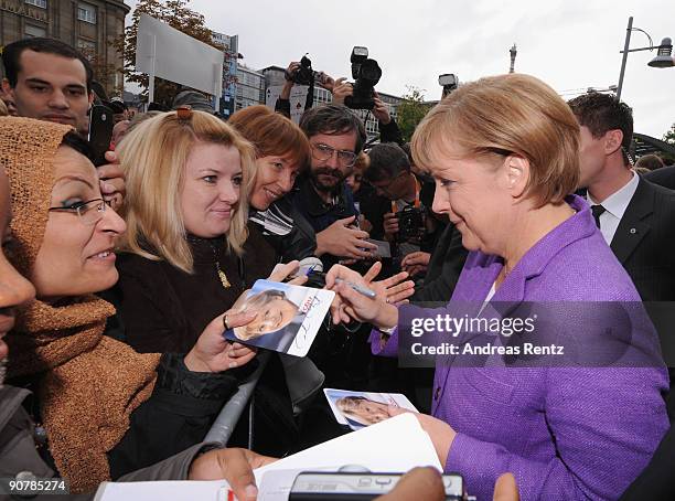 German Chancellor Angela Merkel of the Christian Democratic Union signs autographs on her first stop in Koblenz during her campaign journey in the...