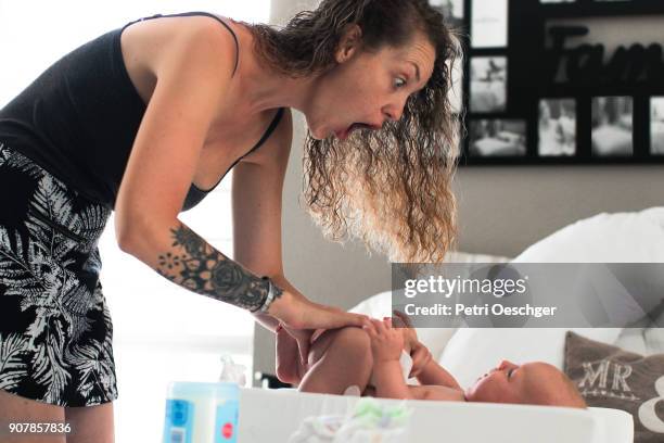 bonding with mom. - changing diaper imagens e fotografias de stock