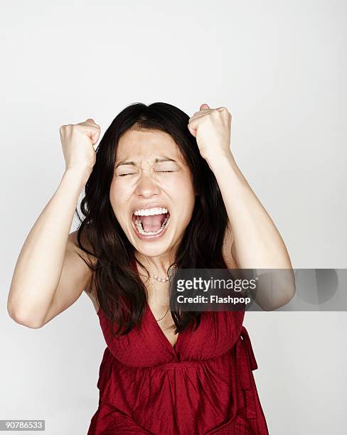 portrait of woman looking frustrated - gridare foto e immagini stock